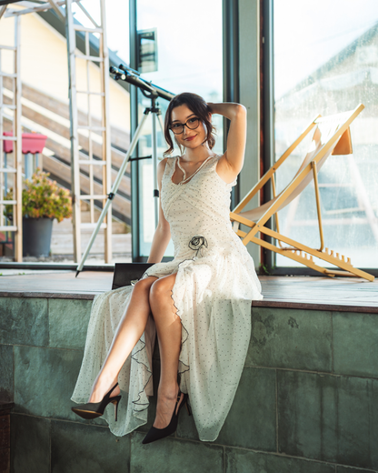 Robe longue blanc cassé à pois noirs avec volants, fente et fleur en tissu