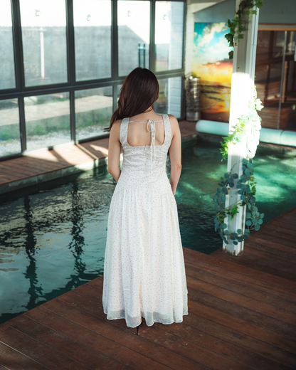 Robe longue blanc cassé à pois noirs avec volants, fente et fleur en tissu